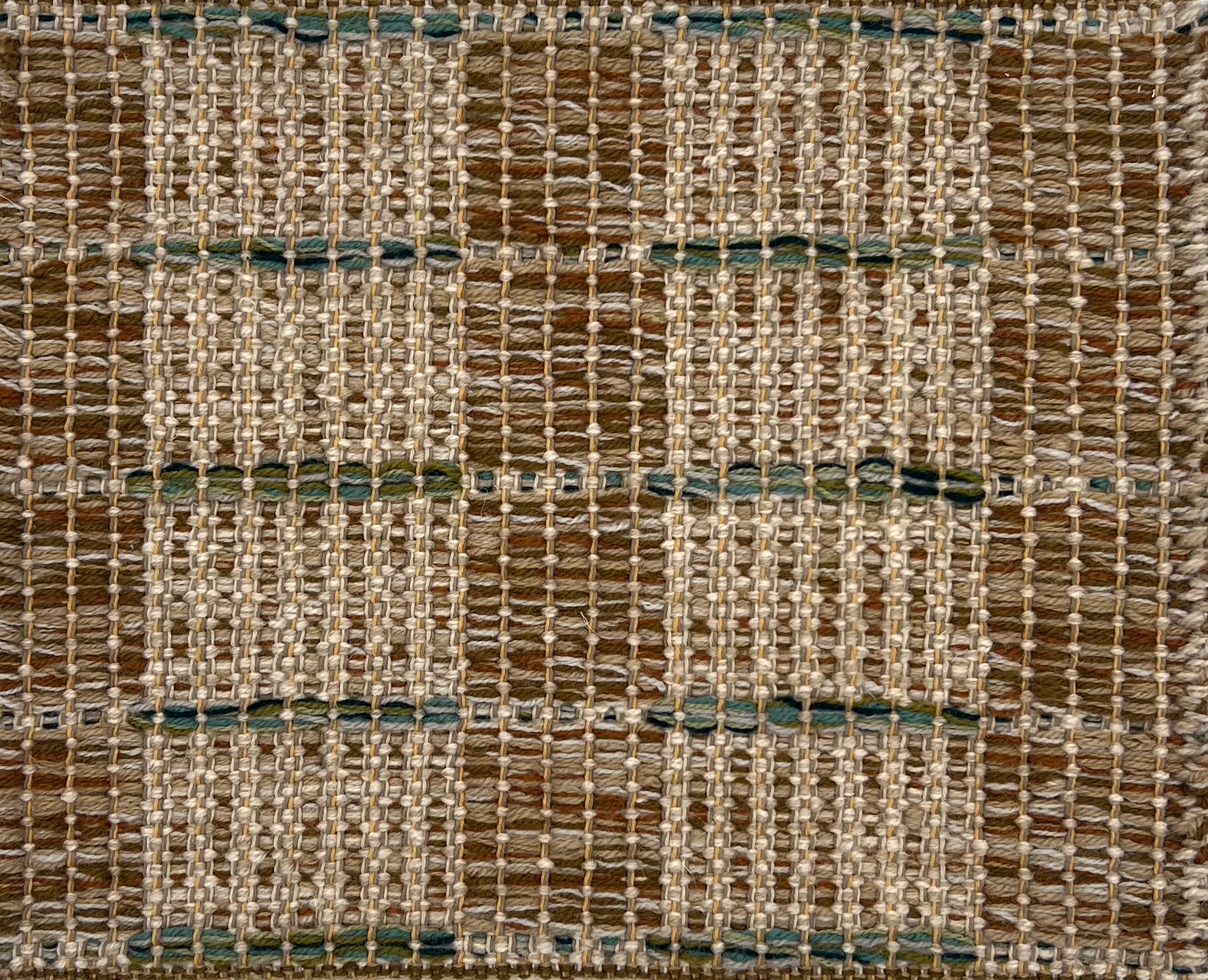 Textural flatweave rug in a modern check pattern in brown and tan with green accents.