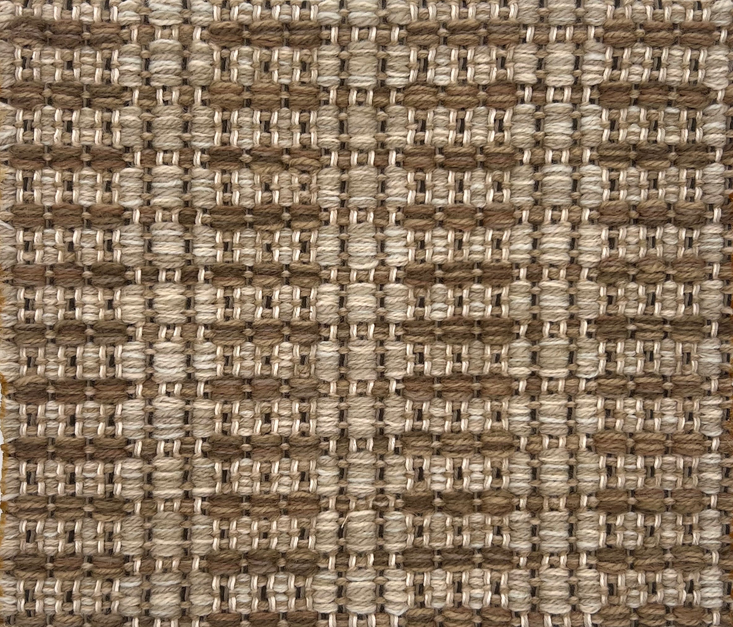 Textural flatweave rug in a stripe check pattern in tan and bronw.
