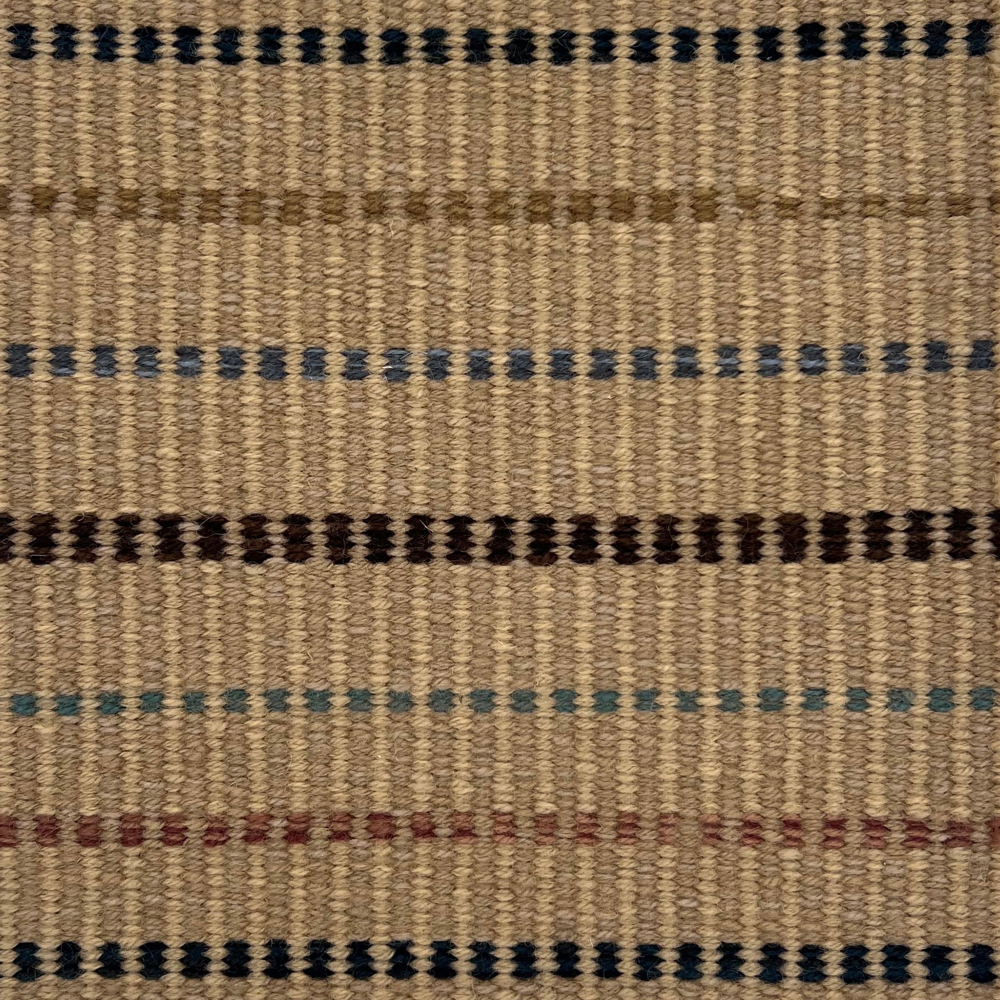 Textural flatweave rug with a dashed stripe design in brown, rust, tan, blue and teal on a tan field.