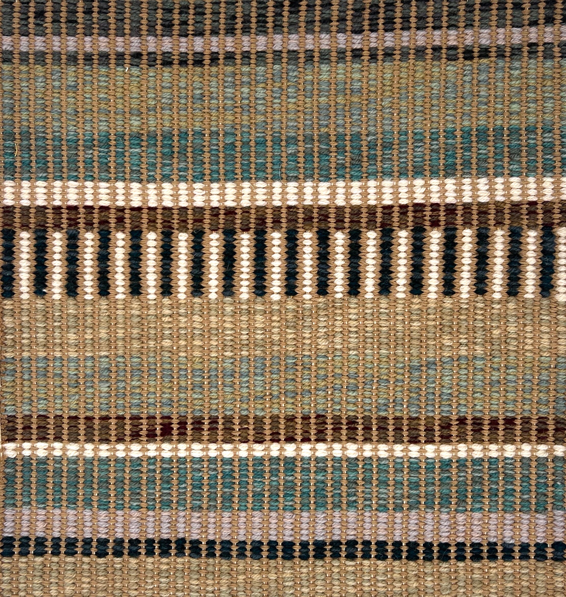 Textural flatweave rug in a varigated stripe design in brown, teal, green and cream.