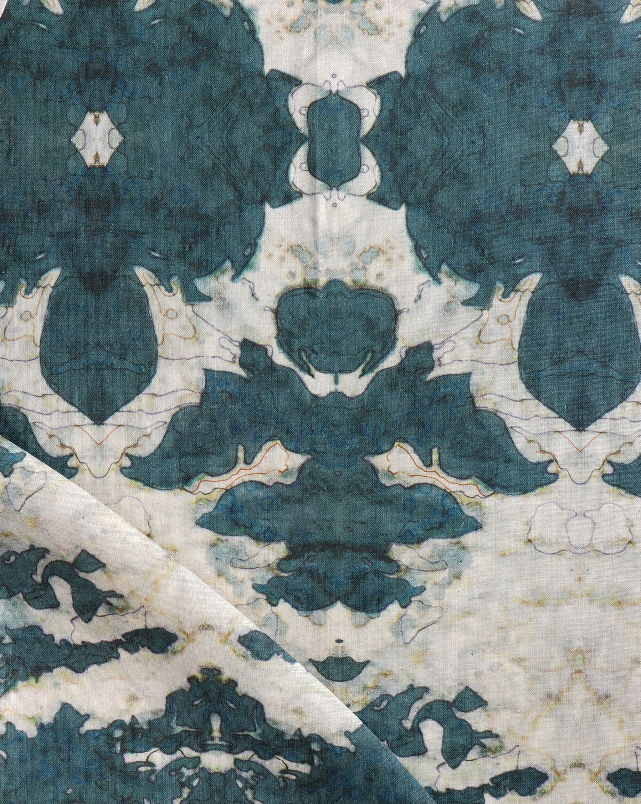 Draped fabric yardage in a watercolor ikat print in shades of turquoise and yellow on a cream field.