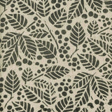 Detail of fabric in a repeating leaf print in dark green on a tan field.