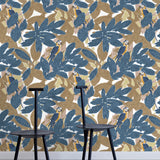 Two minimalist black chairs stand in front of a wall papered in a botanical and parrot print in blue, brown and yellow.