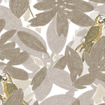 Detail of fabric in a playful botanical and parrot print in shades of gray, brown and yellow on a white field.