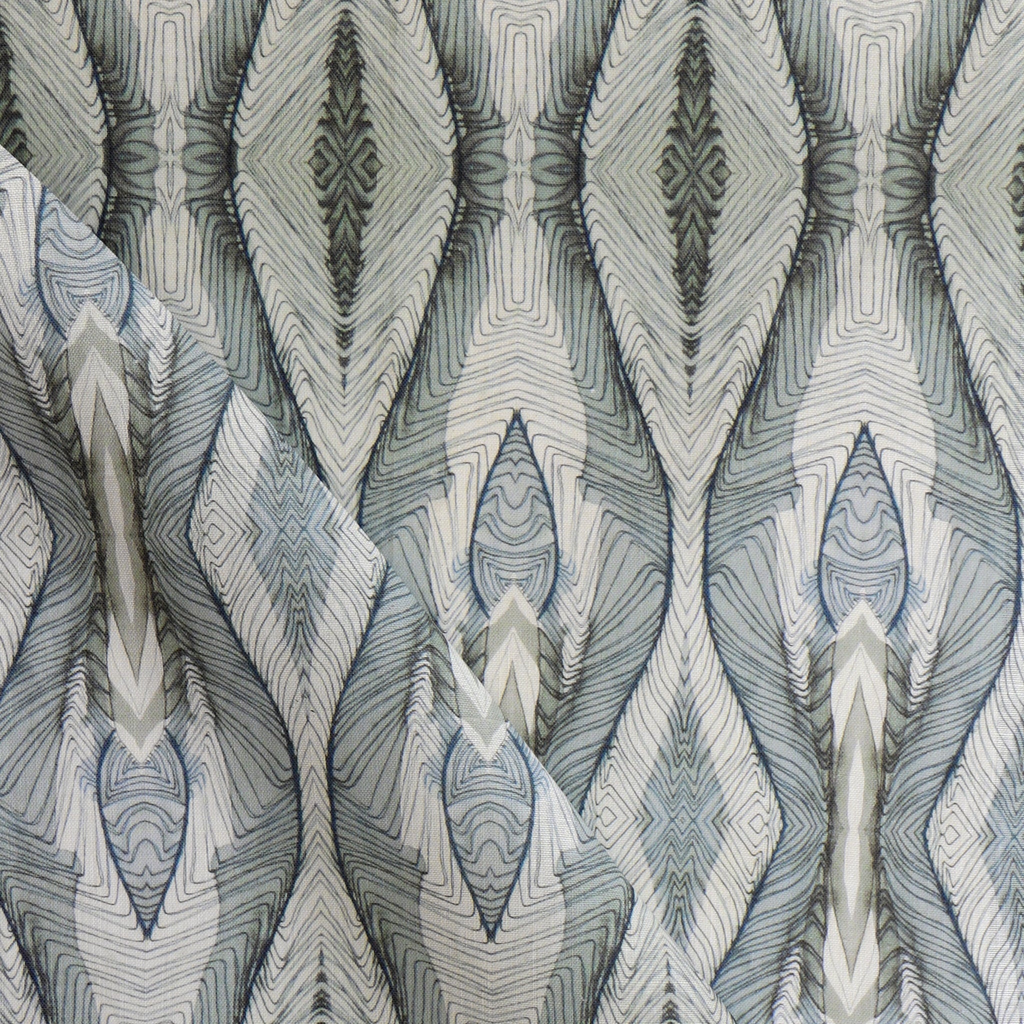 Draped fabric yardage in a watercolor diamond print in shades of gray and navy on a cream field.