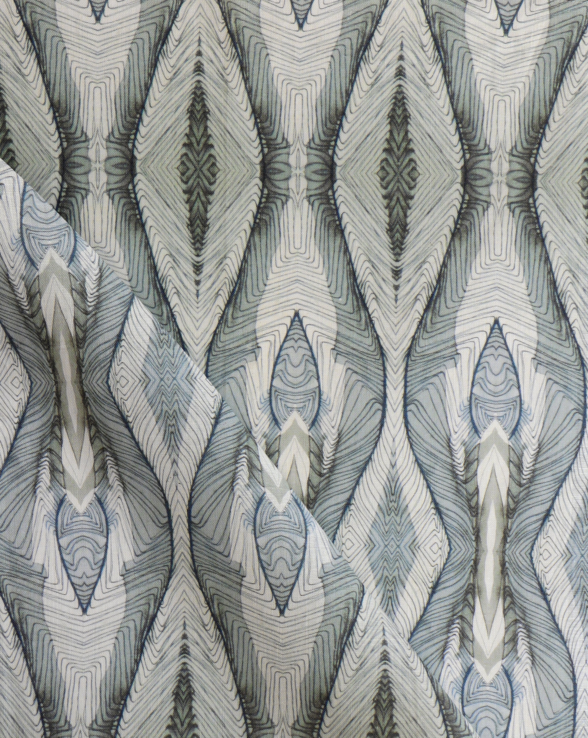Draped fabric yardage in a watercolor diamond print in shades of gray and navy on a cream field.
