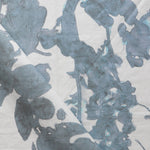 Draped fabric yardage in a watercolor tree print in blue and turquoise on a cream field.