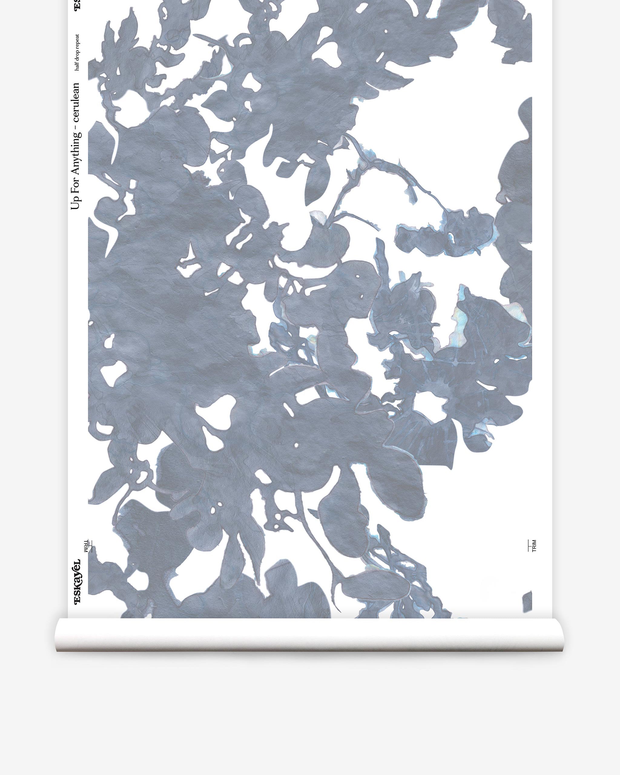 Partially unrolled wallpaper yardage in a watercolor floral print in shades of gray and blue on a white field.