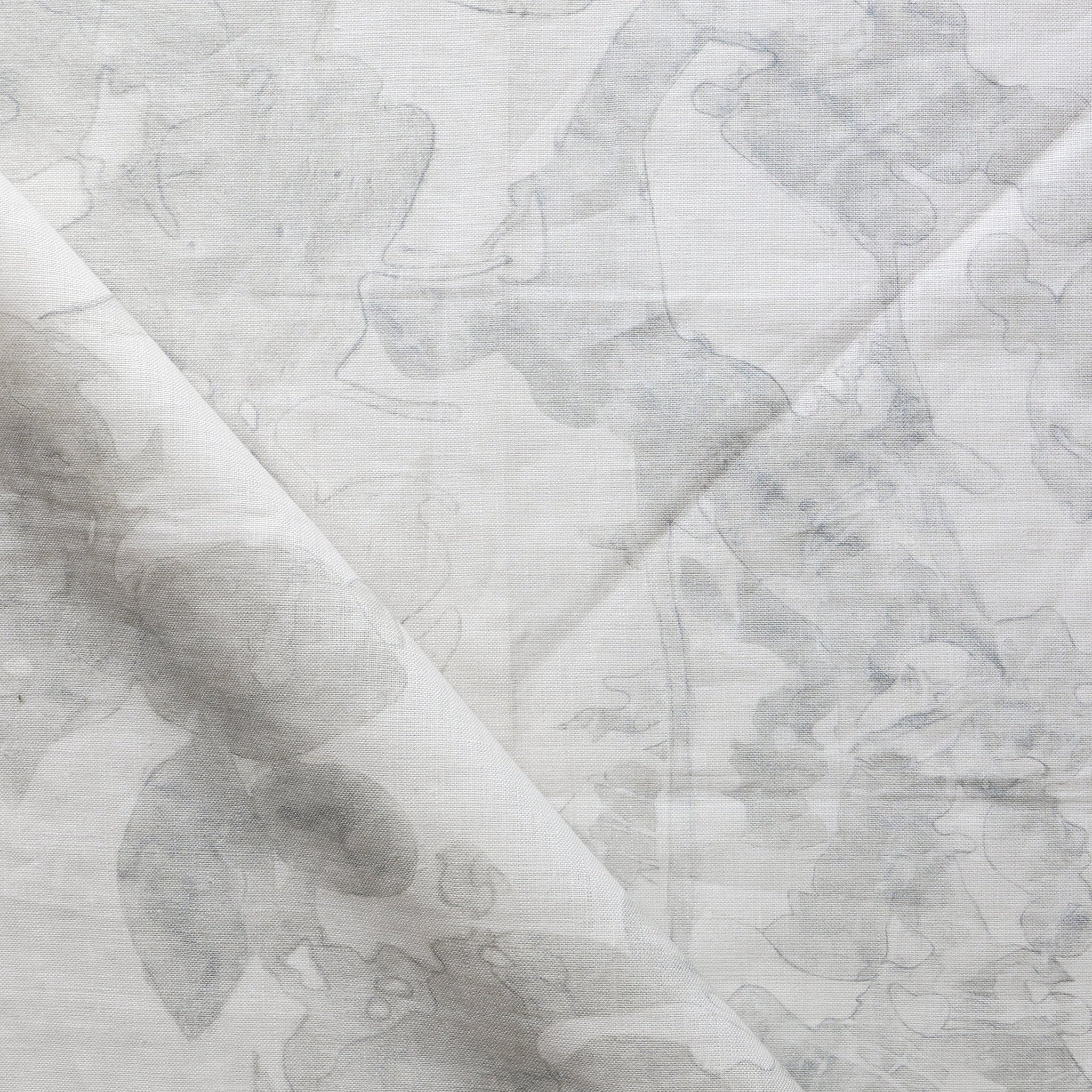 Draped fabric yardage in a watercolor tree print in shades of gray on a cream field.