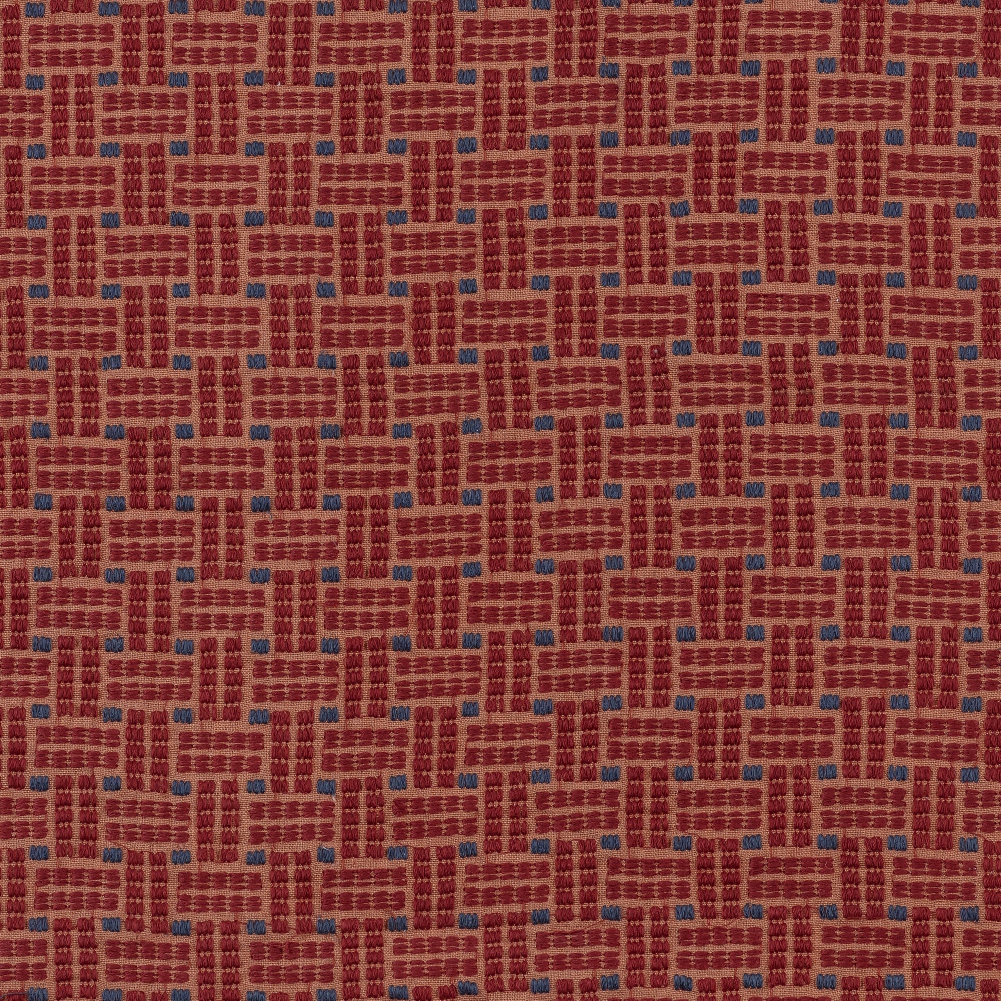 Embroidered fabric in a dashed basketweave design in red with blue accents.