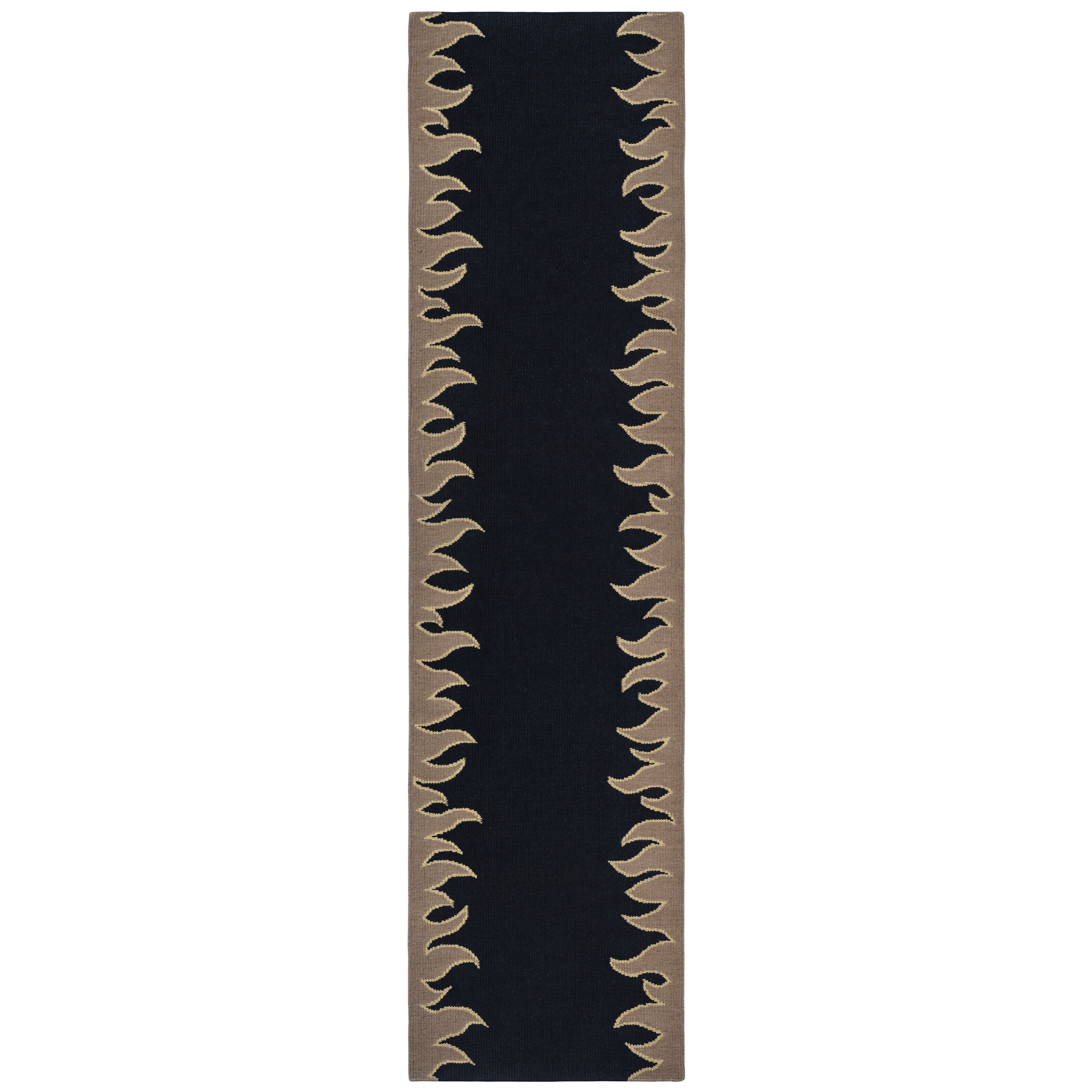 Flatweave runner with a flame border design in taupe on a black field. 