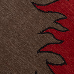 Detail of a handknotted rug with a flame border design in red on a brown field. 