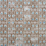 Wallpaper in a repeating damask print in blue and white on a brown field.