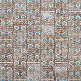 Wallpaper in a repeating damask print in blue and white on a brown field.