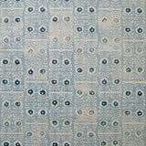 Wallpaper in a repeating damask print in navy and cream on a light blue field.