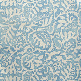 Wallpaper in a botanical paisley print in cream on a light blue field.