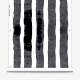 Wallpaper roll  with bold watercolor stripes in black and white on a white background. 