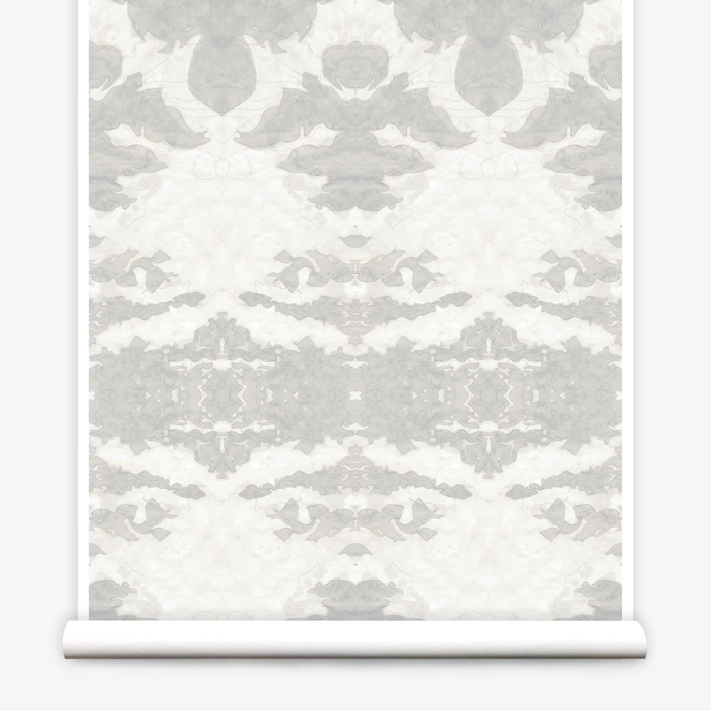 Partially unrolled wallpaper yardage in a painterly ikat print in shades of gray and cream.
