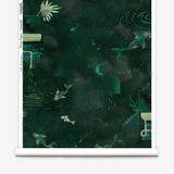 Partially unrolled wallpaper yardage in a playful koi pond print in shades of green and yellow on a black field.