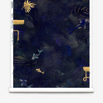 Partially unrolled wallpaper yardage in a playful koi pond print in shades of navy and gold on a black field.