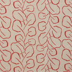 Woven fabric swatch with a large-scale repeating leaf print in red on a tan background.