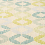 Detail of Alhambra Rug in Mint featuring a pattern of linked circles that create a star like lattice in a range of pastel turquoise, mint, yellow and lime green on a soft beige field. 