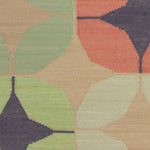 Detail of Alhambra Rug in Venetia featuring pattern of linked circles that create a star like lattice in a range of coral, mustard tyellow, seafoam green, pale green and royal purple accents on a tan field. 