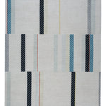 Full size Amelia Rug in Camara featuring a minimalist broken stripe pattern, overlayed with thin white diagonal lines. The broken stripes are a mix of black, pale blue and turquoise with accents of red and bright yellow, all on a soft grey field
