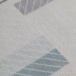 Detail of the Amelia Rug in Pearl featuring a minimalist broken stripe pattern, overlayed with thin white diagonal lines. The broken stripes are a mix of pale blues, grey, and turquoise with slate grey accents, all on a pale grey field. 