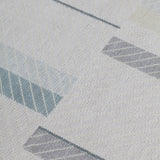 Detail of the Amelia Rug in Pearl featuring a minimalist broken stripe pattern, overlayed with thin white diagonal lines. The broken stripes are a mix of pale blues, grey, and turquoise with slate grey accents, all on a pale grey field. 