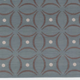 Detail of the Boe rug in Argento, featuring a pattern of curved segments in grey with white circles on a blue field. 
