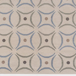 Detail of the Boe rug in Genoa, featuring a pattern of curved segments in light blue and sage green with taupe circles on an ivory field. 