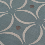 Detail of the Boe rug in Argento, featuring a pattern of white curved segments with taupe circles on a blue field. 