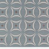Detail of the Boe rug in Argento, featuring a pattern of white curved segments with taupe circles on a blue field. 