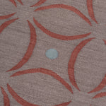 Detail of the Boe rug in Tivoli, featuring a pattern of crimsoncurved segments with light blue circles on a heather purple field. 