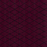 Detail of the Bucky Rug in berry, features a wide black border with a wine colored lattice field with a metallic sheen. 