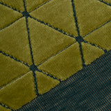 Detail of the Bucky Rug in citrine-jade, features a wide dark sage green border with a chartreuse colored lattice field with a metallic sheen. 