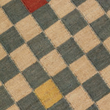 Detail of the Checkerboard Rug in bishop, a blue and white checkered pattern with random accents of red and yellow. 