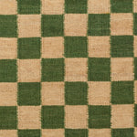Detail of the Checkerboard Rug in Pawn, a green and tan checkered pattern. 