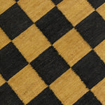 Detail of the Checkerboard Rug in Queen, a black and ochre yellow checkered pattern. 