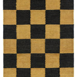 Detail of the Checkerboard Rug in Queen, a black and ochre yellow checkered pattern. 