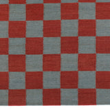 Detail of the Checkerboard Rug in Pawn, a red and sky blue checkered pattern. 
