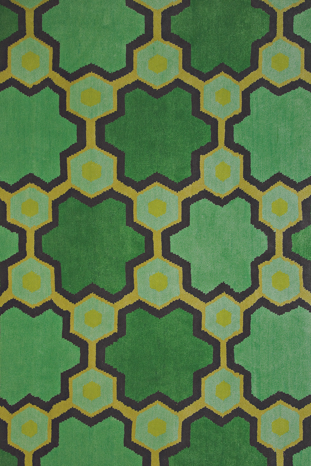 Detail of the Cordoba Cut Pile Rug in Emerald, a hexagonal lattice pattern with sahdes of emerald, jade, yelow and chcolate brown. 