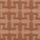 Detail of the Iseo Rug in Conch, a textural monochromatic abstract geometric pattern in terracotta coral color. 