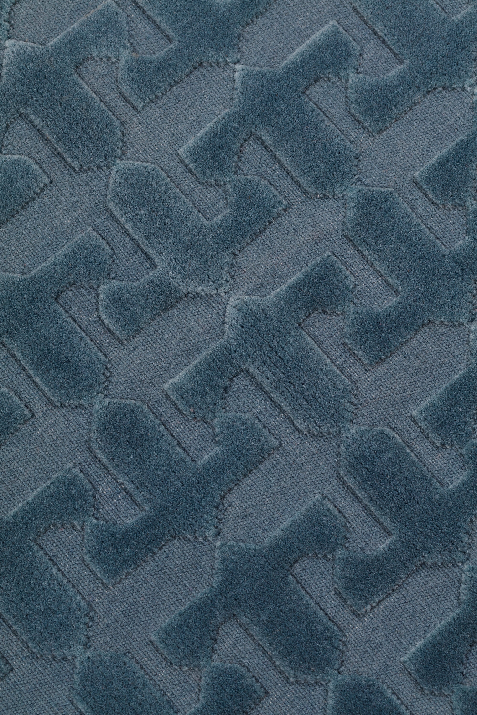 Detail of the Rug in Stormy Sky, a textural monochromatic abstract geometric pattern in blue. 
