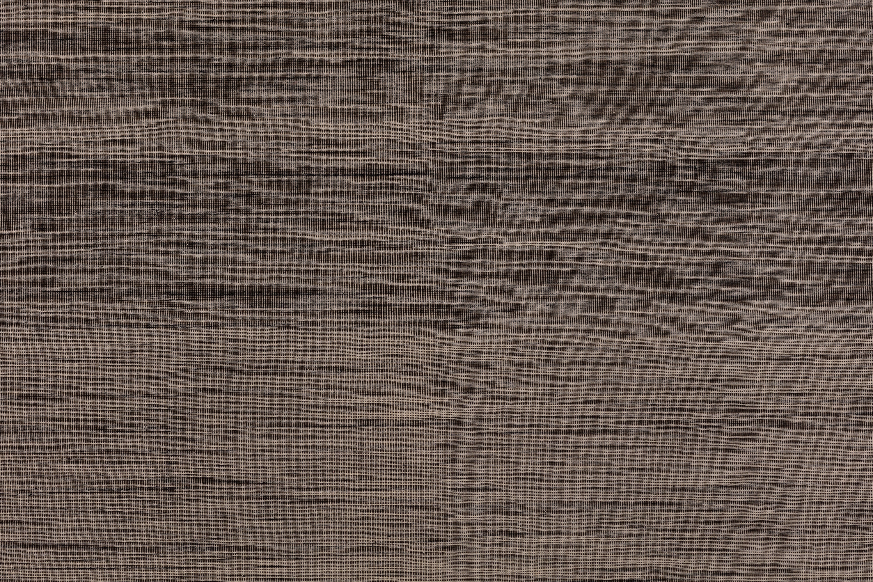 Detail of the Moire Rug in Rockpool, a subtle striated pattern tan and black. 
