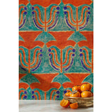 Silver bowl of persimmons in front of wallpaper with stamped painted floral motif in vibrant red and cobalt on an emerald green background, hover