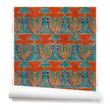 Wallpaper roll with a stamped painted floral motif in vibrant red and cobalt on an emerald green background
