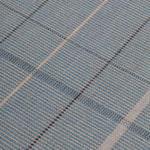 Detail of the Jasper Waffle Rug in Chalcedony, a large scale plaid pattern of denim blue, black, yellow and pale turqouise. 