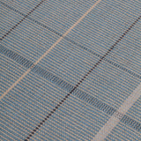 Detail of the Jasper Waffle Rug in Chalcedony, a large scale plaid pattern of denim blue, black, yellow and pale turqouise. 